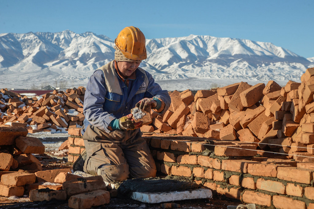 Dépourvus d'accès à la mer, les pays enclavés doivent compter sur d'autres nations pour leurs importations et leurs exportations. Sur cette photo, une femme construit une maison en Mongolie.
